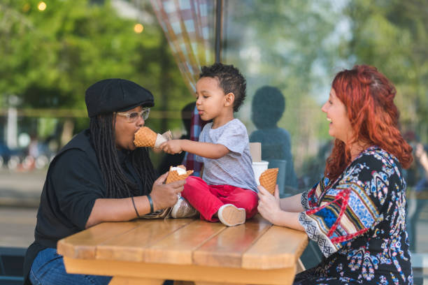 istock Two moms eat ice cream with their three-year old son 1028534562