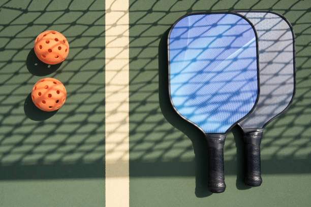 istock Pickleball paddles and ball on court 1028580224