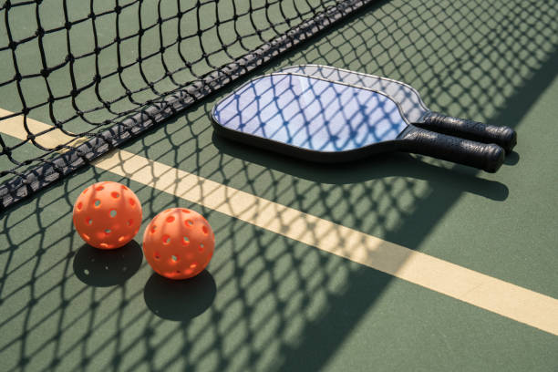istock Pickleball paddles and ball on court 1028580480
