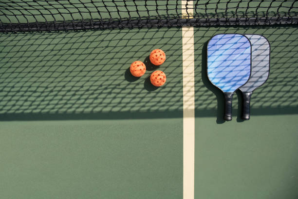 istock Pickleball paddles and ball on court 1028580802