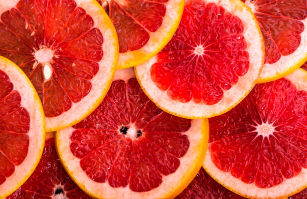 istock Sliced grapefruits, background, natural texture of citrus, top view, close-up 1028590426