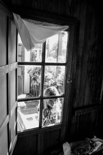istock Girl at beach house. Window. 1028590910