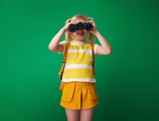 istock smiling school girl looking through binoculars 1028596598