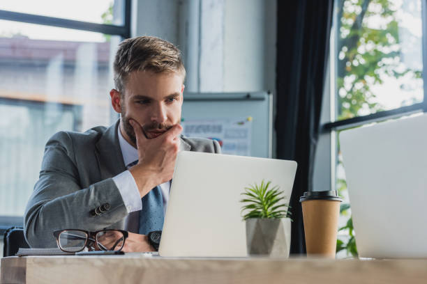 istock focused young businessman using laptop in office 1028602530