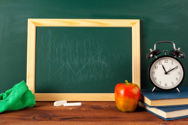 istock back to school - apple and books with pencils and blackboard 1028606270