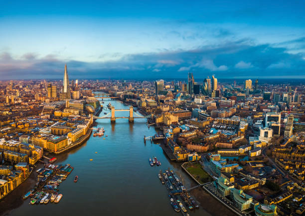 London, England - Panoramic aerial skyline view of London including Tower Bridge with red double-decker bus, Tower of London, skyscrapers of Bank District London, England - Panoramic aerial skyline view of London including Tower Bridge with red double-decker bus, Tower of London, skyscrapers of Bank District and other famous skyscrapers at golden hour thames river photos stock pictures, royalty-free photos & images