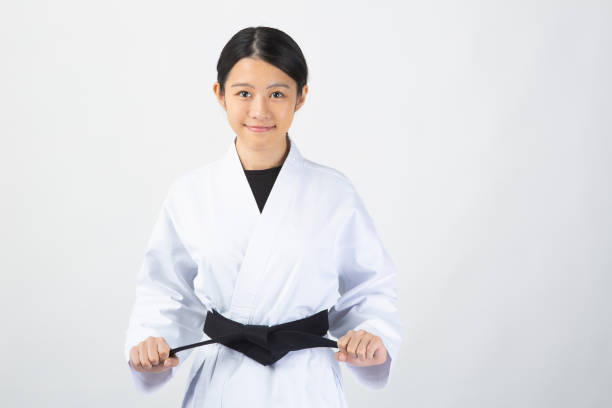 istock Woman wearing Karate uniform holding black belt 1028647212