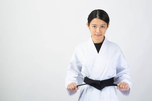 istock Woman wearing Karate uniform holding black belt 1028647236