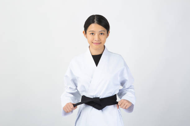 istock Woman wearing Karate uniform holding black belt 1028647286