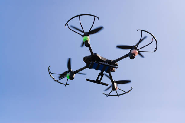istock Flying drone or quad copter in blue sky. 1028651384