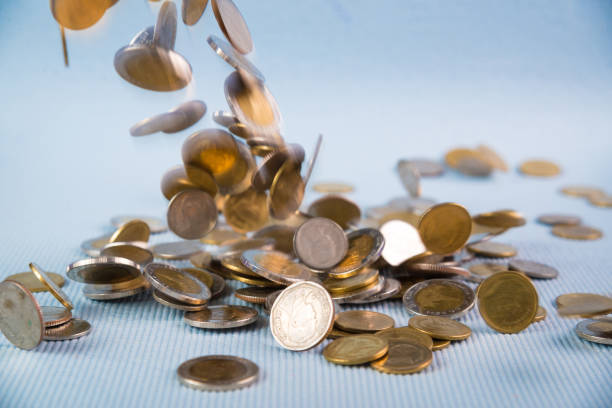 istock Falling coins money on blue background, business wealth concept. 1028651762