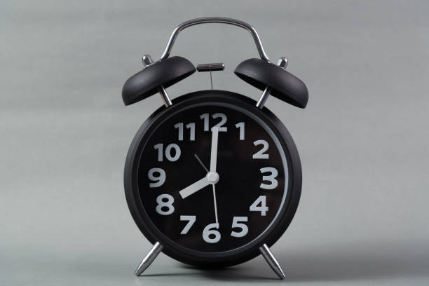 istock Black color vintage alarm clock, on grey background. wake up time concept. 1028651774