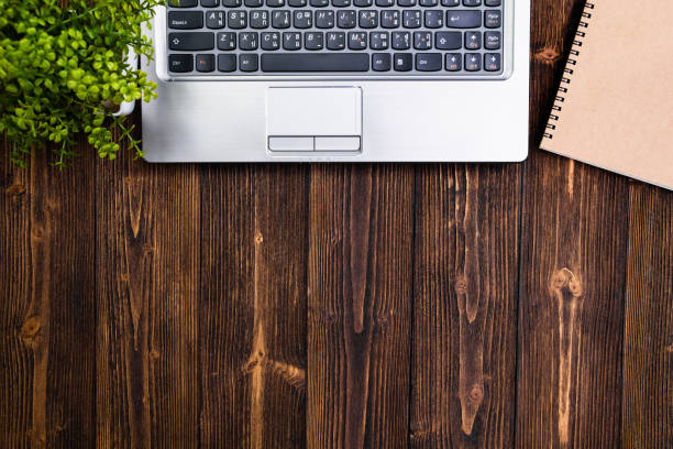istock Office supplies or office work essential tools or items on wooden desk in workplace, laptop computer notebook calculator and alarm clock, top view with copy space and message. 1028651902
