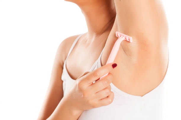 istock woman shaves her armpits on white background 1028653084