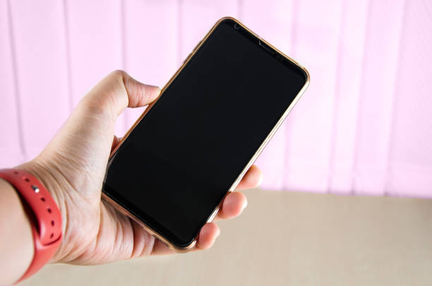 istock A hand holds a smartphone on the office background 1028665460