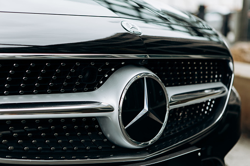 Berlin, August 29, 2018: A close-up of the Mercedes Benz sign on the new black Mercedes-Benz SLC. The inscription in German is translated as young stars.