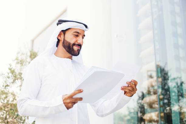 Arabian businessman Middle eastern businessman in kandora looking at documents united arab emirates stock pictures, royalty-free photos & images