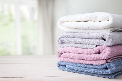 Colorful folded towels stack on table empty copy space.