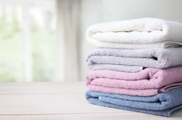 Photo of Towels stack on table empty space background.
