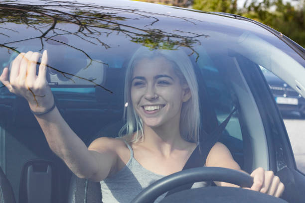 istock blonde young girl driving a car 1028691118