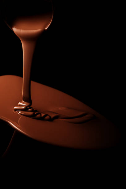 chocolate fundido con flujo chocolate con backgroung negro - chocolate topping fotografías e imágenes de stock