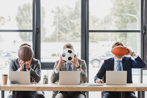 trabajadores de oficina joven sosteniendo bolas al trabajar con ordenadores portátiles en la oficina photo