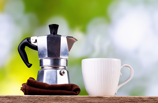 Coffee cup and coffee pot with blurred background