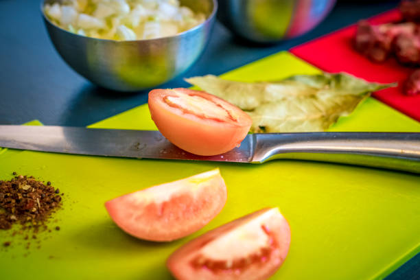 Ingredients for beef stew on cutting boards. Carrots, tomato, onion, peper and bay leaf.