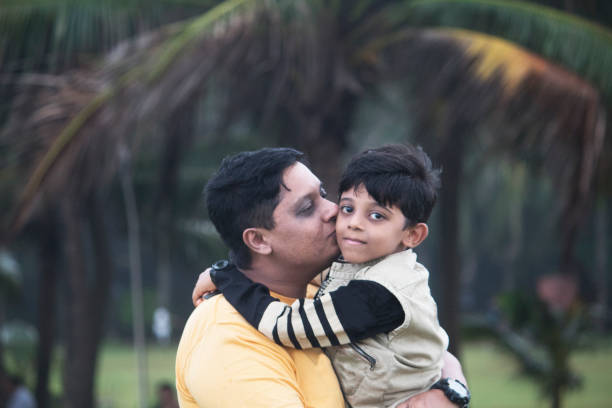 istock Father kissing son at park 1028718346