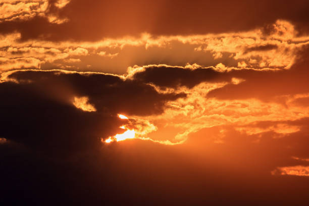istock Dramatic sky with dark clouds and orange sun at sunset 1028724130