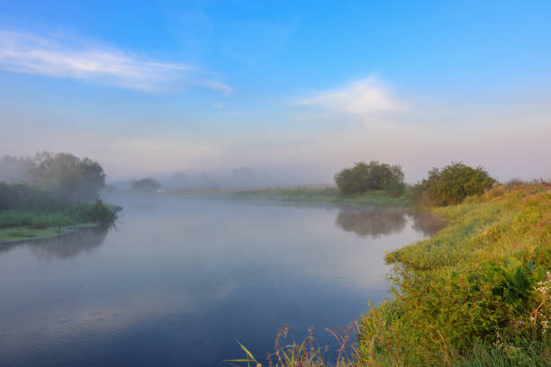 River with fog above surface. River landscape at sunny summer morning