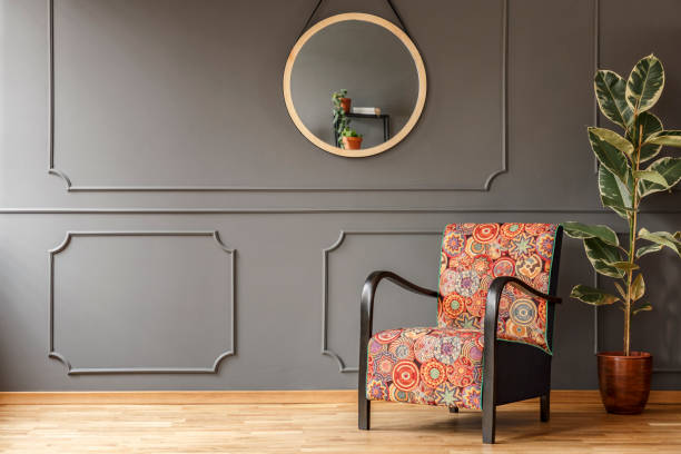 istock Ficus next to patterned armchair against grey wall with molding and mirror in flat interior. Real photo 1028733008