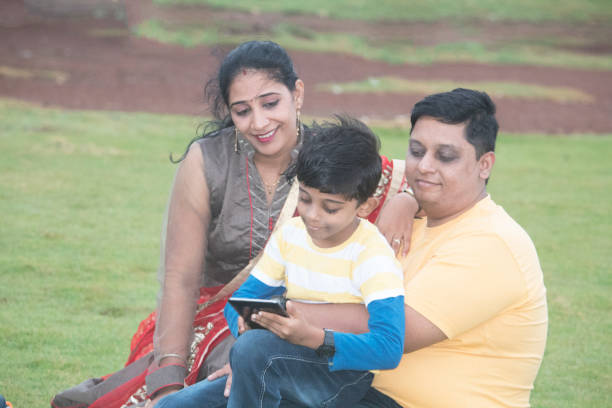istock Family with digital tablet at park 1028733176