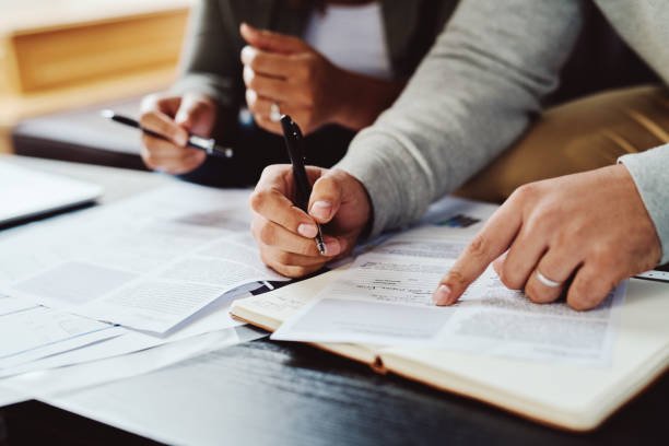 Never overlook the fine print Closeup shot of an unrecognizable couple going through paperwork together at home filling out stock pictures, royalty-free photos & images