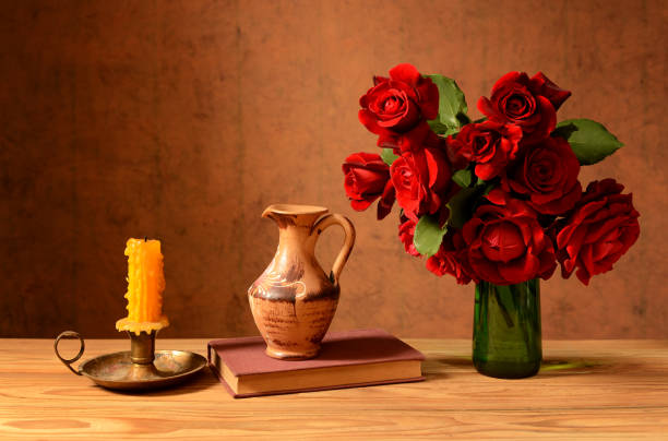 Roses in a vase, books and candles on the table