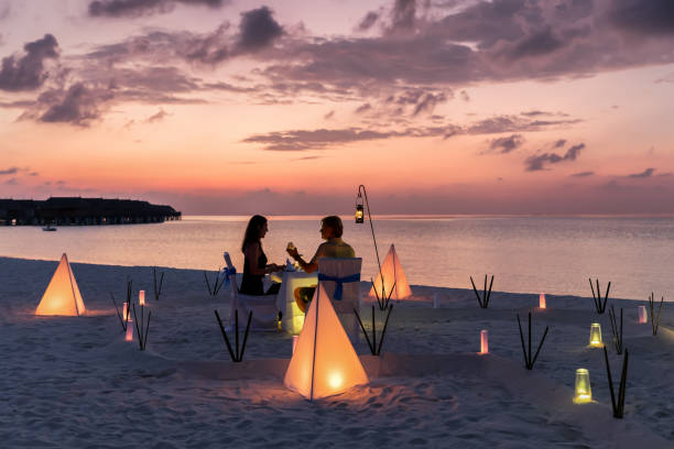Honeymoon travel concept on a tropical beach Couple is having a private event dinner on a tropical beach during sunset time: Honeymoon travel concept military private stock pictures, royalty-free photos & images
