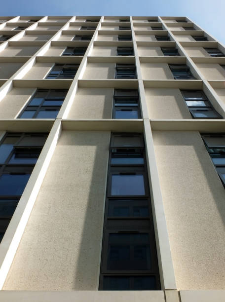istock vertical view of a tall concrete angular modern high building with geometric white details against a blue sky 1028753952