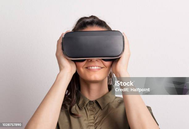 Ritratto Di Una Giovane Bella Donna Con Occhiali Vr In Studio - Fotografie stock e altre immagini di Simulatore di realtà virtuale