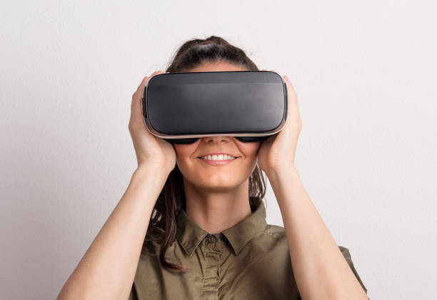 portrait of a young beautiful woman with vr goggles in studio. - women young adult isolated length imagens e fotografias de stock