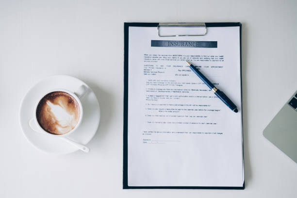 istock Pen on Insurance contract document sheet and business document ,near coffee cup and laptop computer in home office, Business and Office concept. 1028758198