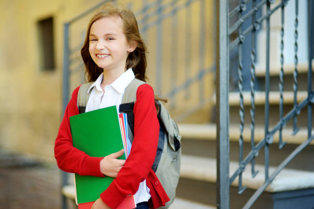 istock Adorable little schoolgirl studying outdoors on bright autumn day. Young student doing her homework. Education for small kids. 1028761054