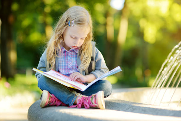 istock Adorable little schoolgirl studying outdoors on bright autumn day. Young student doing her homework. Education for small kids. 1028761192