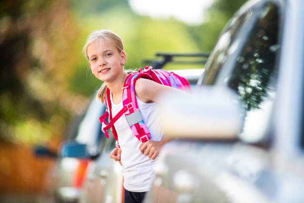 Cute little girl going home from school Cute little girl going home from school, looking well before crossing the street way to school stock pictures, royalty-free photos & images