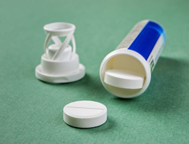 istock Scattered pills and a jar on a green background 1028779446