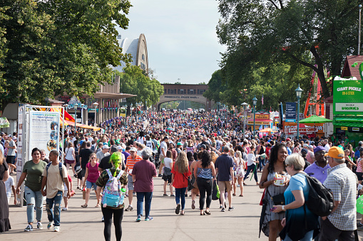 ST. PAUL, MINNESOTA, USA - AUGUST 26, 2018: Crowd of fairgoers walk along one of the busy avenues at the Minnesota State Fair during August of 2018