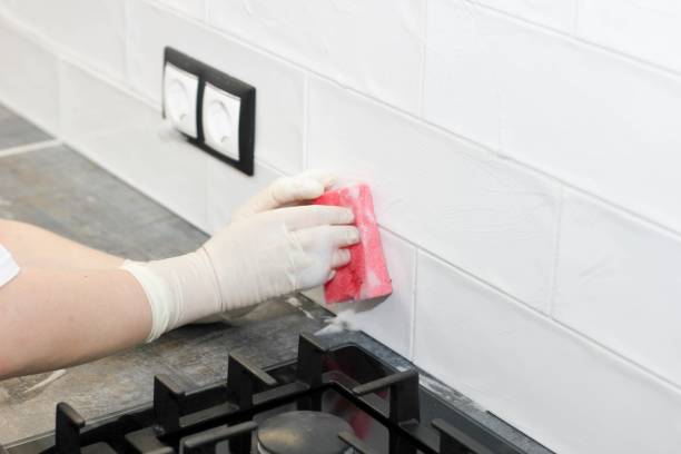 cleaning of the kitchen. cleaning of ceramic tiles on walls stock photo