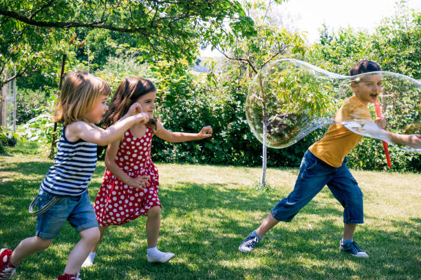 istock Kids having fun with soap bubbles in the park 1028806606