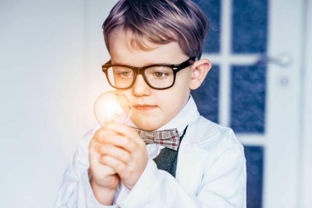 istock Curious child dressed as a scientist looks at light bulb and gets an idea 1028809196