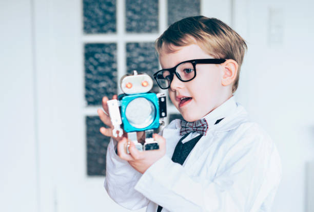 istock Curious child dressed as a scientist plays with an innovative robot 1028809226