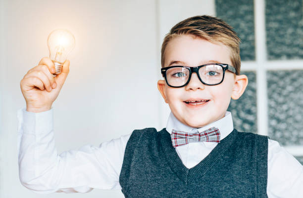 istock Child scientist holds a light bulb and gets an idea 1028809478